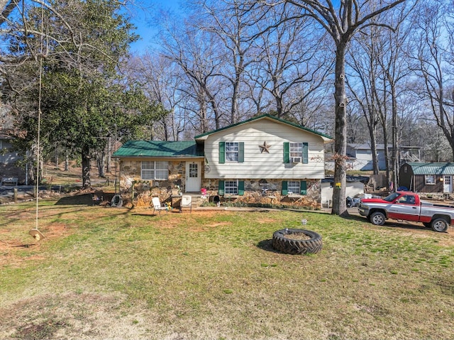 tri-level home with stone siding and a front yard