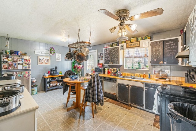 kitchen featuring under cabinet range hood, light countertops, stainless steel appliances, a ceiling fan, and a sink