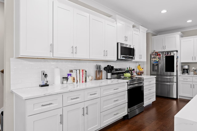 kitchen featuring white cabinets, appliances with stainless steel finishes, dark hardwood / wood-style flooring, and ornamental molding