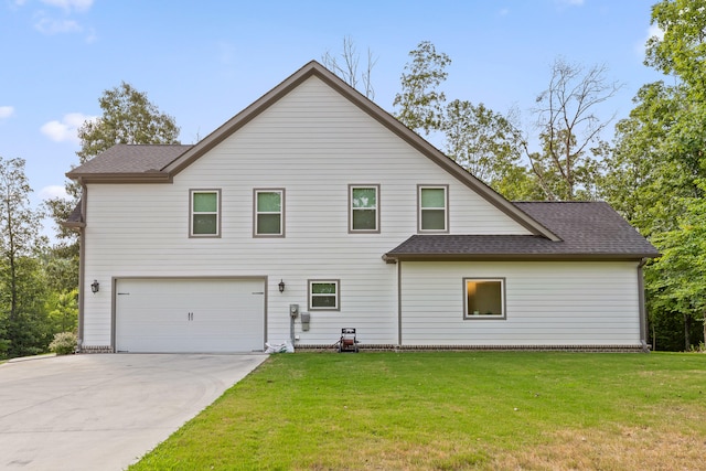 rear view of house featuring a lawn and a garage