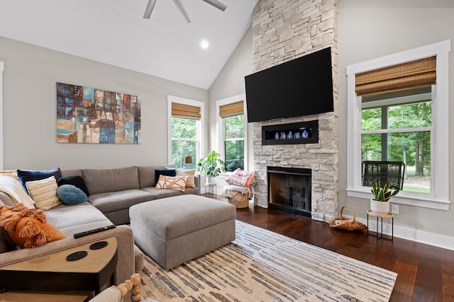 living room with ceiling fan, a fireplace, high vaulted ceiling, and dark wood-type flooring