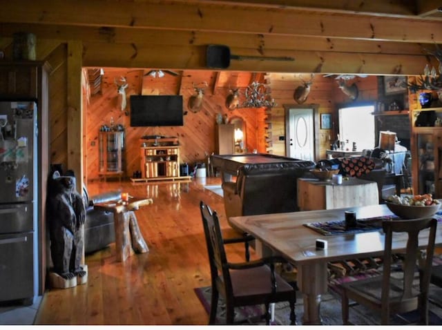 dining room with hardwood / wood-style floors, wooden walls, and pool table