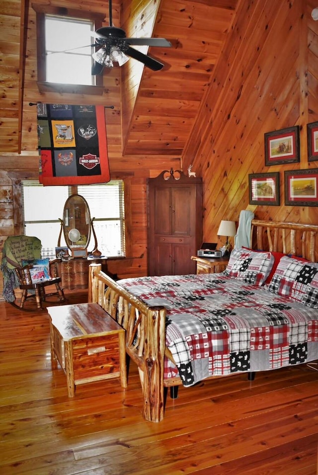 bedroom with ceiling fan, wood walls, wood-type flooring, lofted ceiling, and wood ceiling