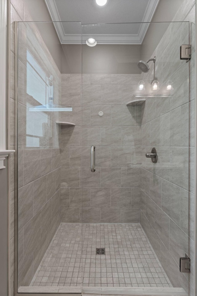 bathroom with crown molding and a stall shower