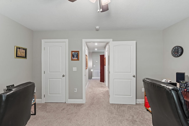 home office with visible vents, a ceiling fan, baseboards, and light carpet