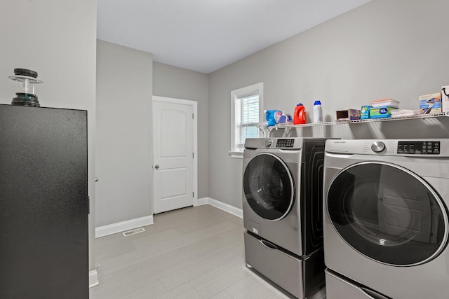 washroom with separate washer and dryer, baseboards, laundry area, and visible vents