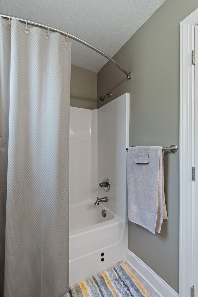 full bath featuring shower / tub combo and baseboards