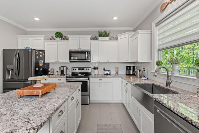kitchen featuring white cabinets, tasteful backsplash, appliances with stainless steel finishes, and a sink