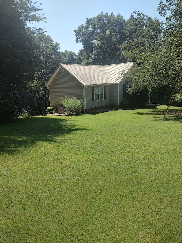 view of side of home with a yard