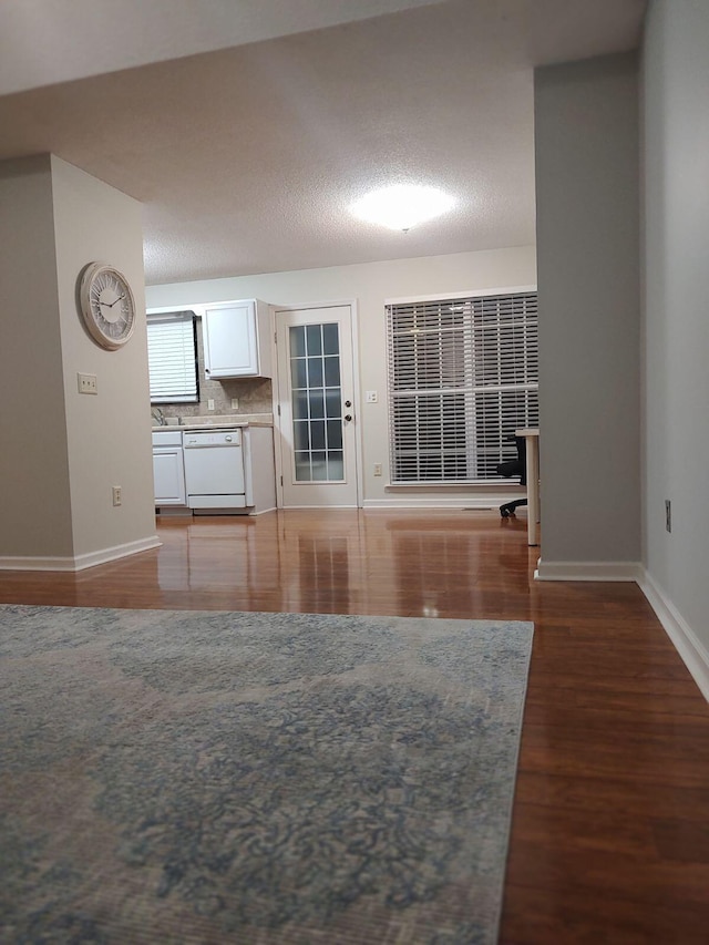 unfurnished living room featuring hardwood / wood-style floors and a textured ceiling