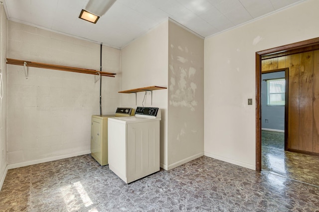 laundry room featuring separate washer and dryer, crown molding, and wood walls