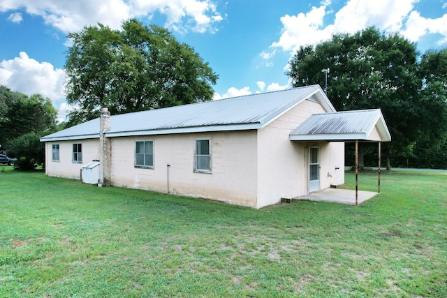 rear view of property featuring a lawn