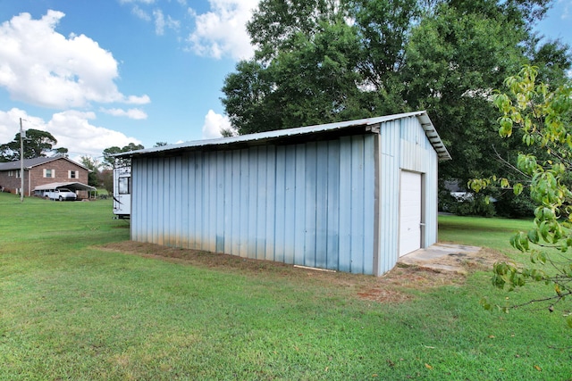 view of outdoor structure featuring a garage and a lawn