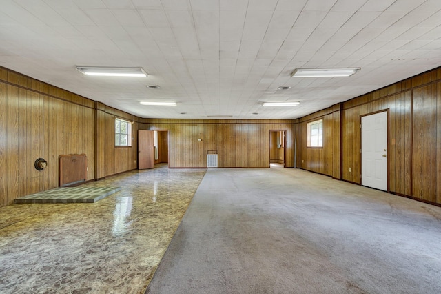 empty room featuring plenty of natural light and wood walls