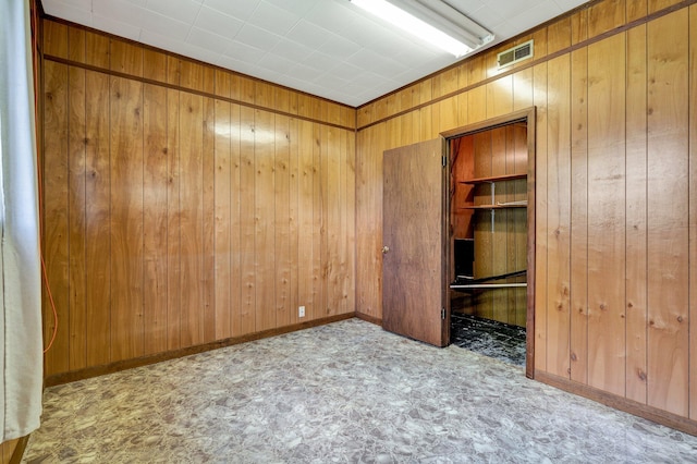 unfurnished bedroom with wooden walls