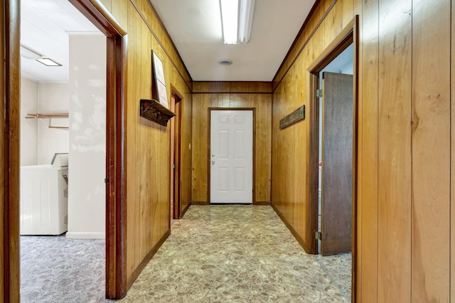 hallway with wooden walls and washer / clothes dryer