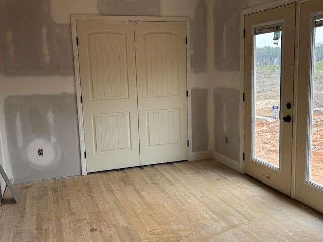 interior space with light wood-type flooring, a closet, and access to outside