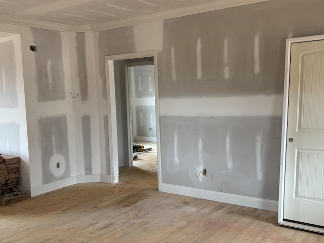 empty room featuring crown molding and light hardwood / wood-style flooring