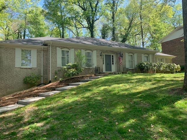 single story home with a front lawn and brick siding