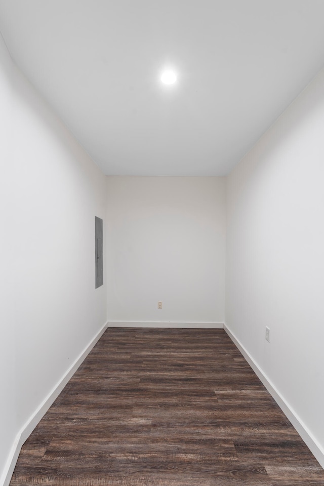 unfurnished room with electric panel and dark wood-type flooring