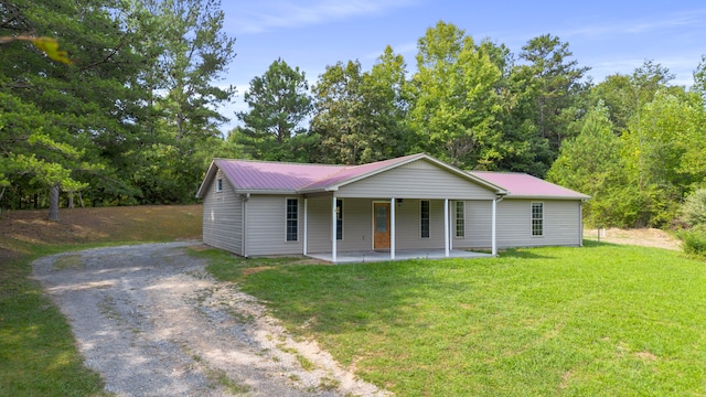 ranch-style home featuring covered porch and a front lawn