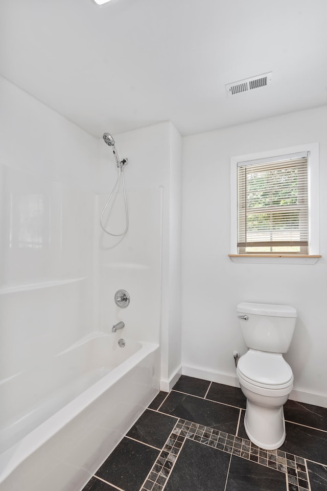 bathroom with tile patterned floors, toilet, and shower / washtub combination