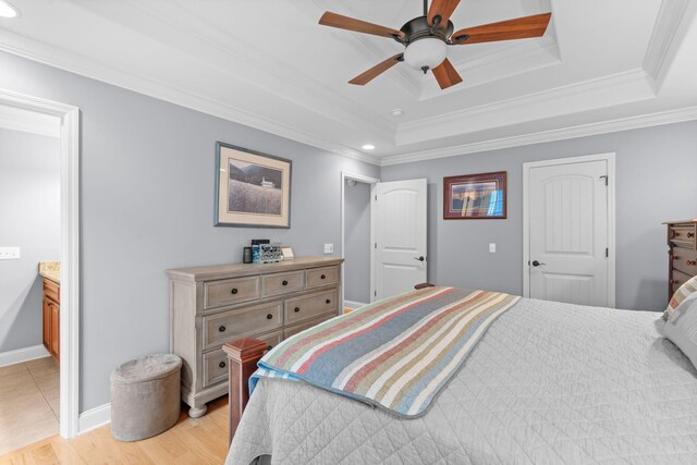 bedroom featuring recessed lighting, light wood finished floors, a raised ceiling, crown molding, and baseboards