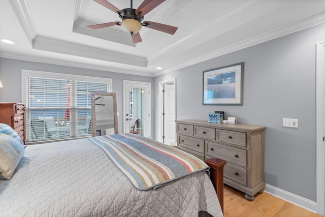 bedroom featuring baseboards, light wood-style floors, a ceiling fan, crown molding, and a raised ceiling
