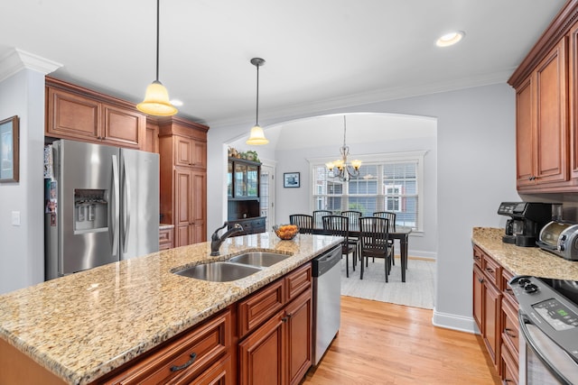 kitchen featuring light wood-style flooring, a sink, a chandelier, crown molding, and appliances with stainless steel finishes