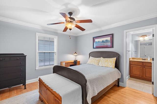 bedroom featuring a ceiling fan, light wood-style floors, baseboards, ensuite bath, and ornamental molding