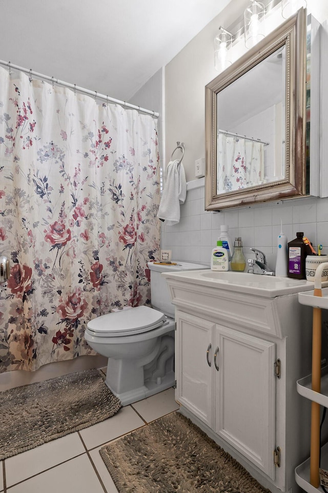 full bath with vanity, a shower with shower curtain, tile walls, toilet, and tile patterned floors