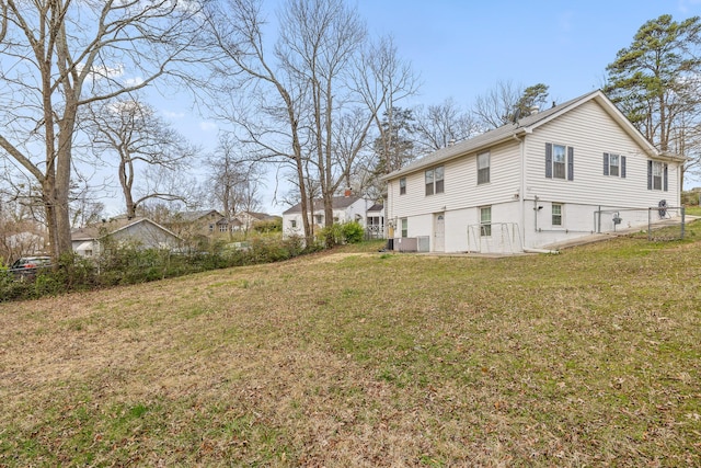 exterior space with a yard, central AC, and fence