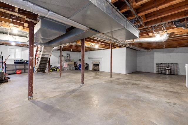 basement featuring stairway and a fireplace