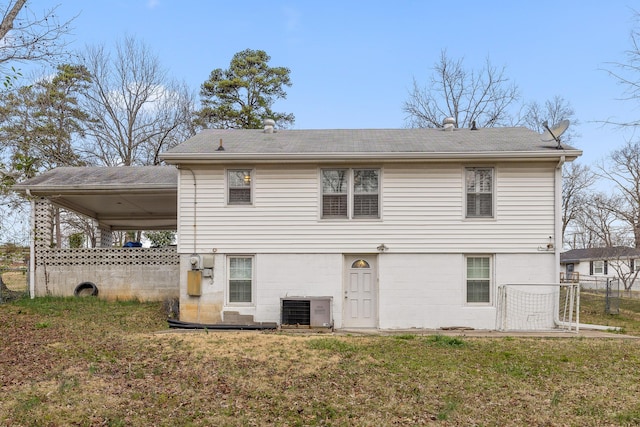 back of property with cooling unit, a shingled roof, a yard, and fence