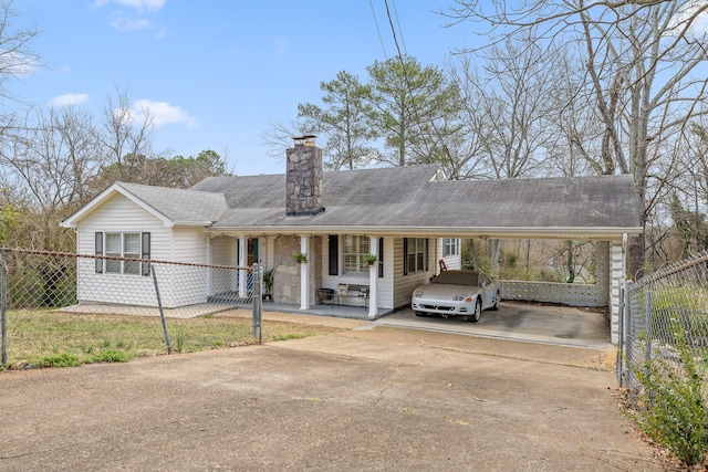 ranch-style home featuring a carport, a chimney, concrete driveway, and fence