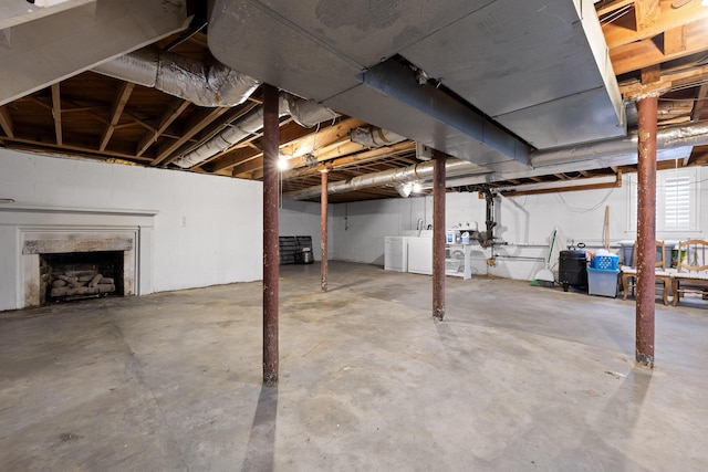 unfinished basement with washer and clothes dryer and a premium fireplace