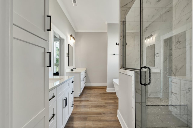 bathroom with wood-type flooring, vanity, separate shower and tub, and ornamental molding