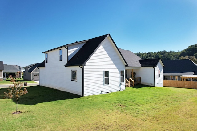 rear view of house featuring a yard