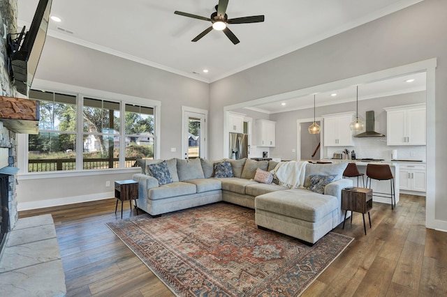 living room featuring ceiling fan, ornamental molding, and dark wood-type flooring