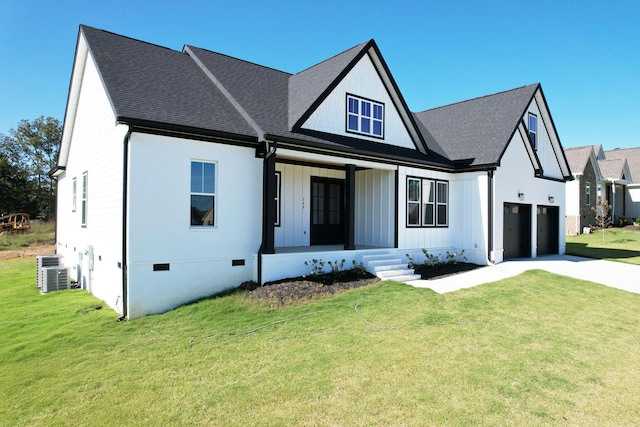 modern farmhouse style home featuring cooling unit, a front lawn, a porch, and a garage