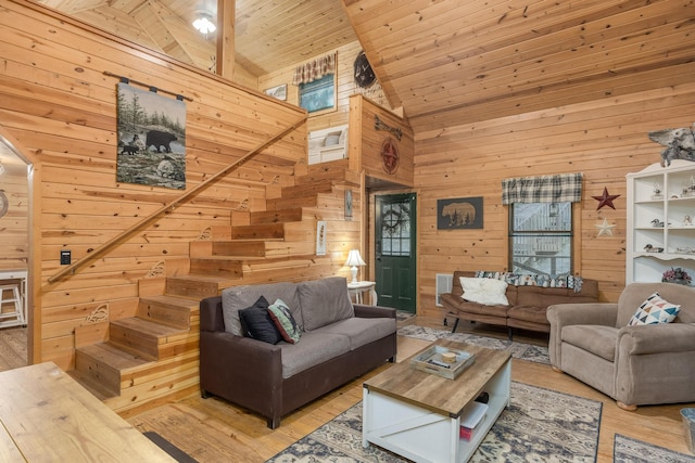 living room with wooden walls, high vaulted ceiling, light hardwood / wood-style floors, and wooden ceiling