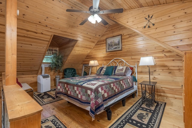 bedroom featuring ceiling fan, wooden ceiling, vaulted ceiling, wooden walls, and light wood-type flooring