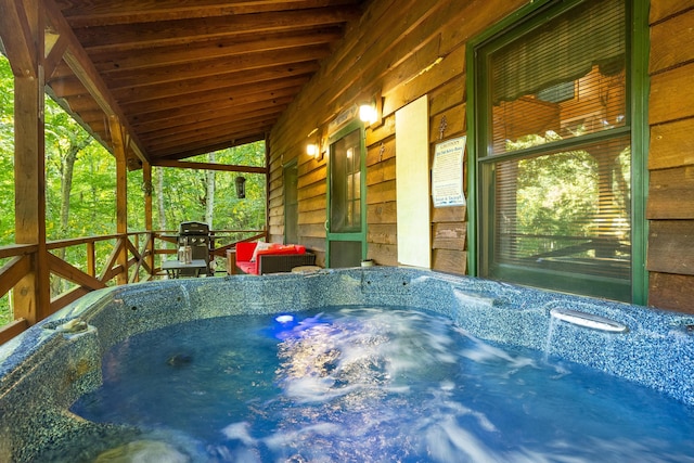 wooden deck featuring a hot tub