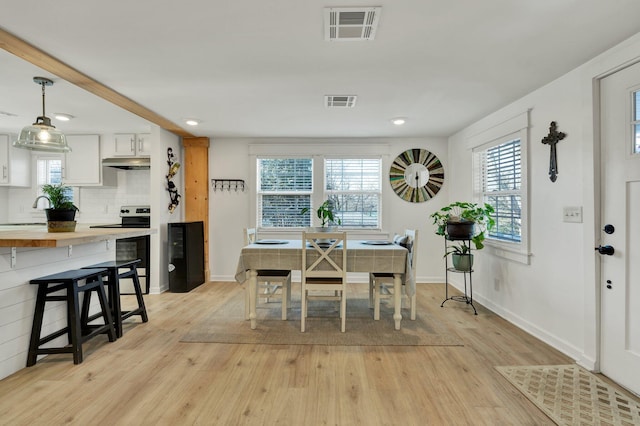 dining space featuring a wealth of natural light, light hardwood / wood-style floors, and sink