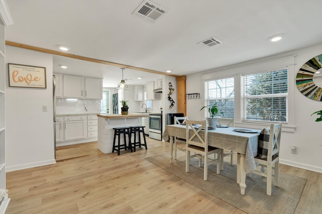 dining space featuring light hardwood / wood-style flooring and sink