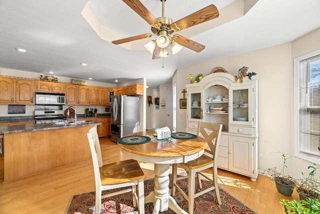 dining space featuring ceiling fan, sink, and light hardwood / wood-style floors