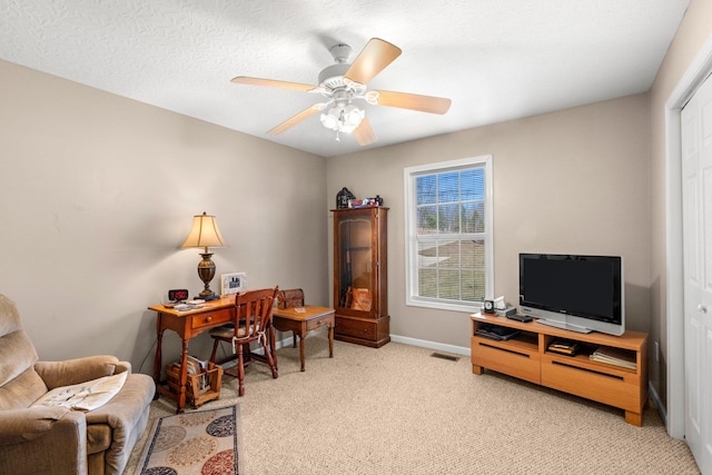 office area with ceiling fan, light colored carpet, and a textured ceiling