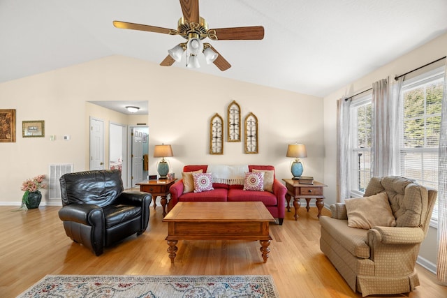 living room with vaulted ceiling, ceiling fan, and light wood-type flooring