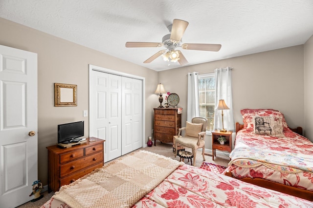 bedroom featuring a textured ceiling, ceiling fan, carpet, and a closet