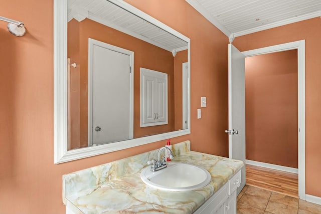 bathroom featuring tile patterned flooring, vanity, and crown molding